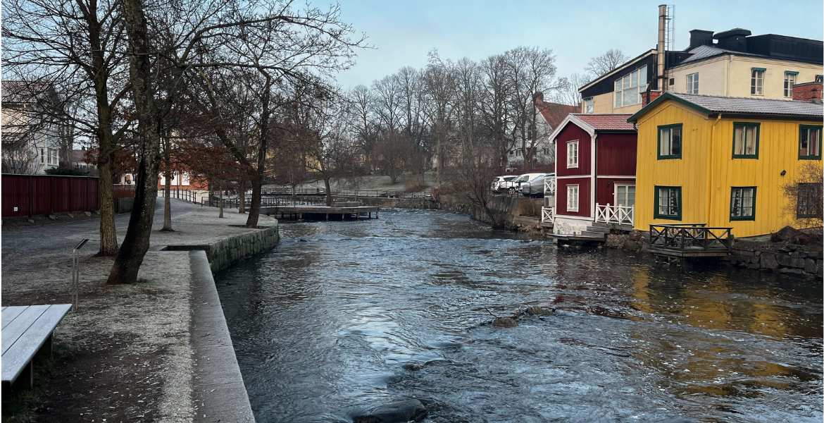 Bild på Norrtäljeån med hus i bakgrunden.